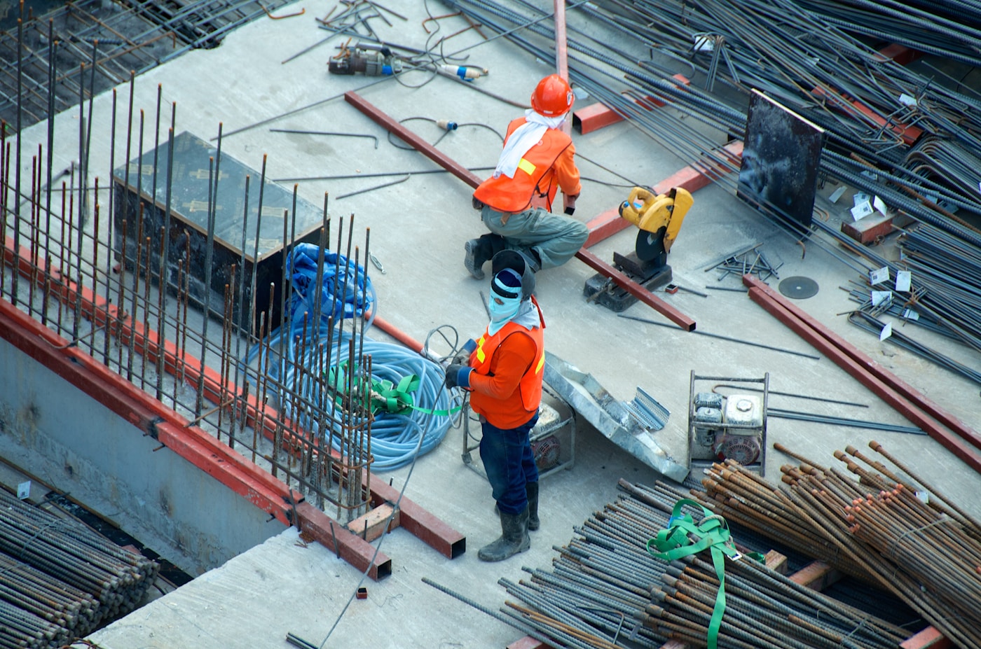 Construction workers and exposed reinforcement at a physical building site